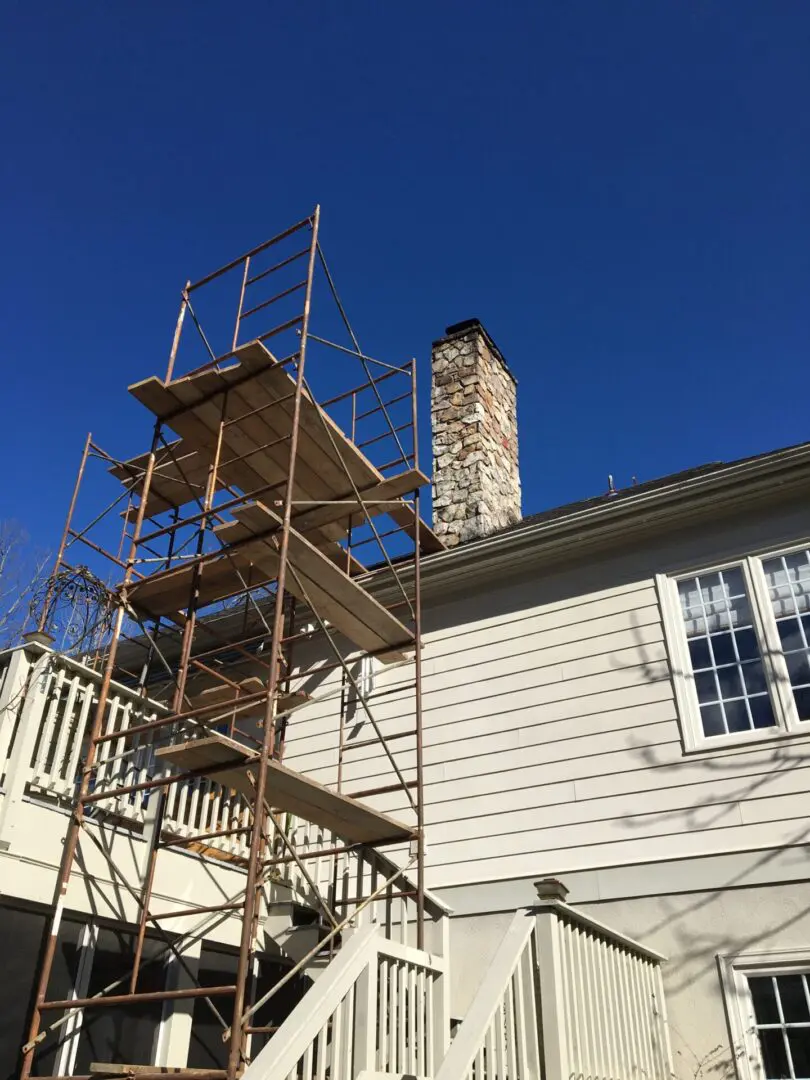 A house with scaffolding around it and a chimney.