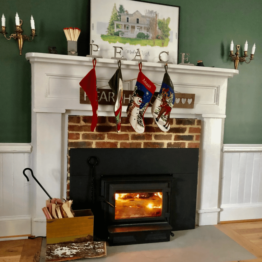 A fireplace with stockings hanging above it.